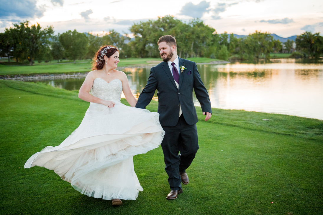 A bride and groom playfully run toward the camera on the golf course at The Barn at Raccoon Creek.